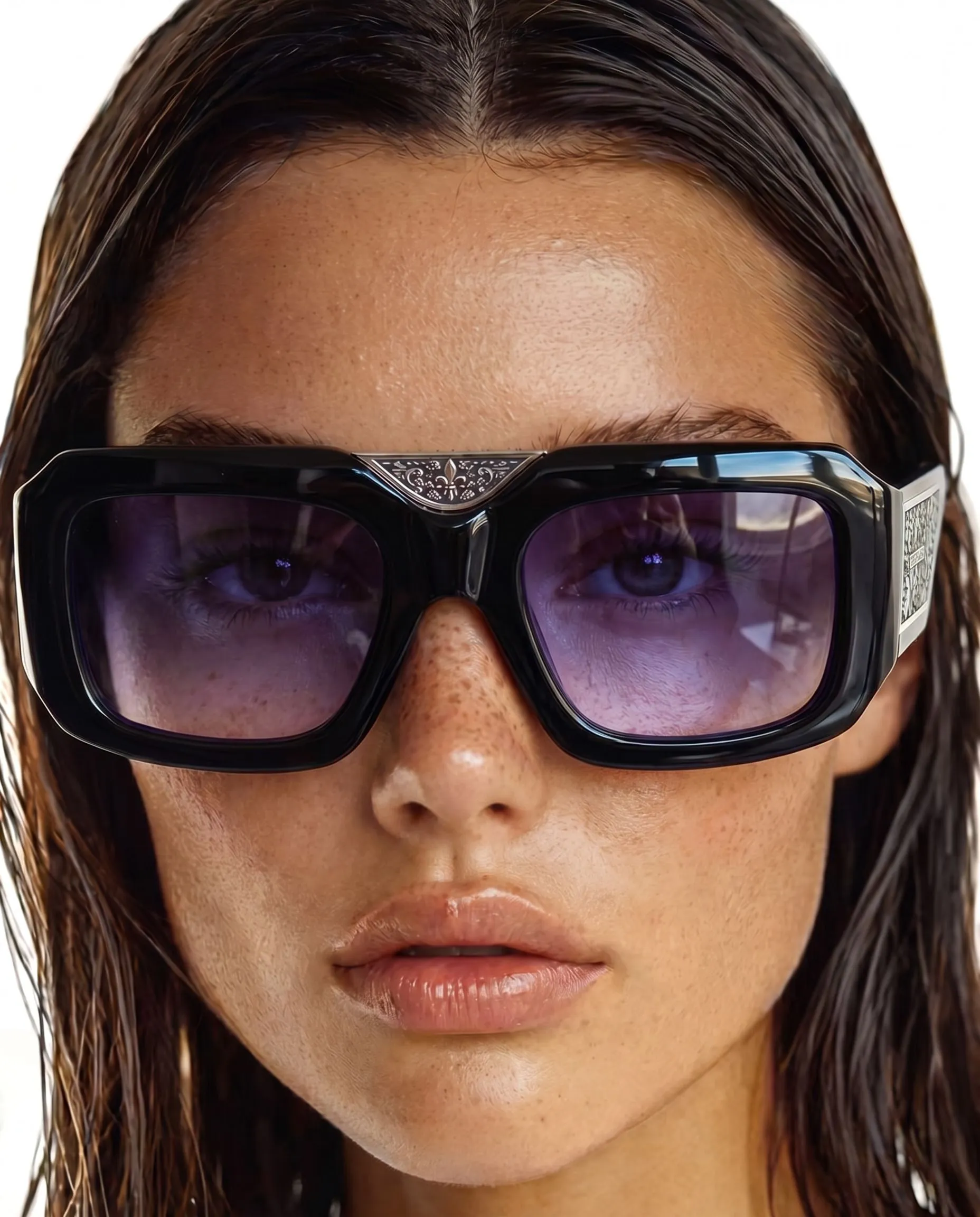 Close-up of a woman with wet, brown hair and tan skin, wearing large black sunglasses with reflective purple lenses.