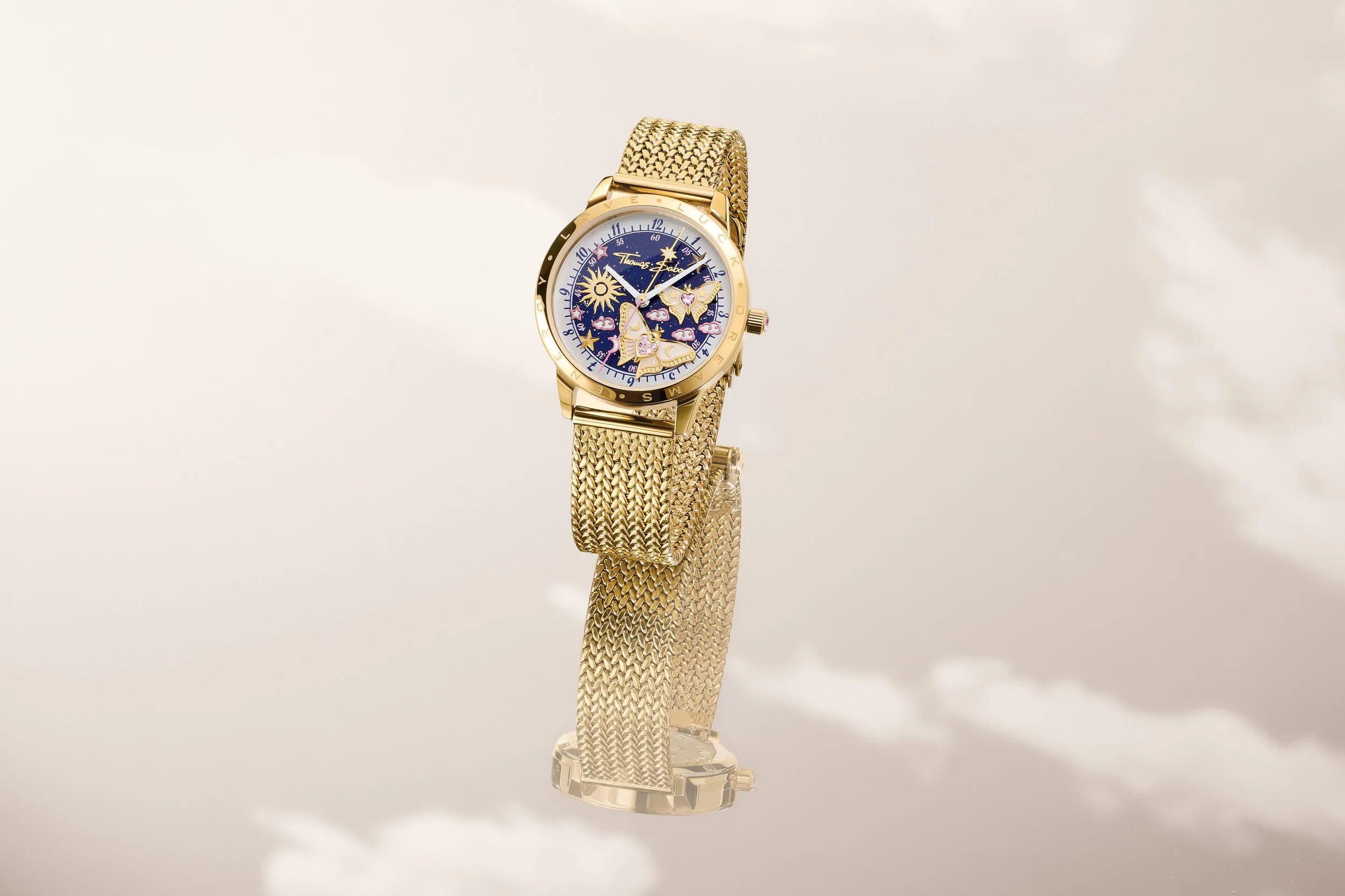 Blooming Sky watch, gold case with a celestial blue dial featuring stars, clouds and a sunburst